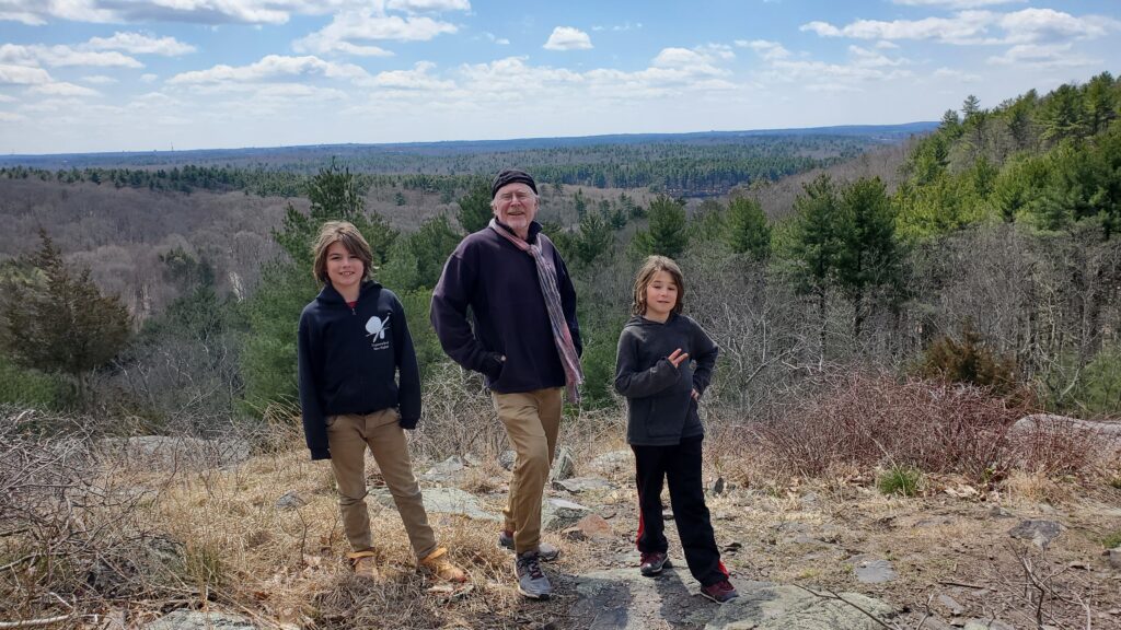 Daddio and the twins at Blue Hills Reservation, with a sweeping vista in the background